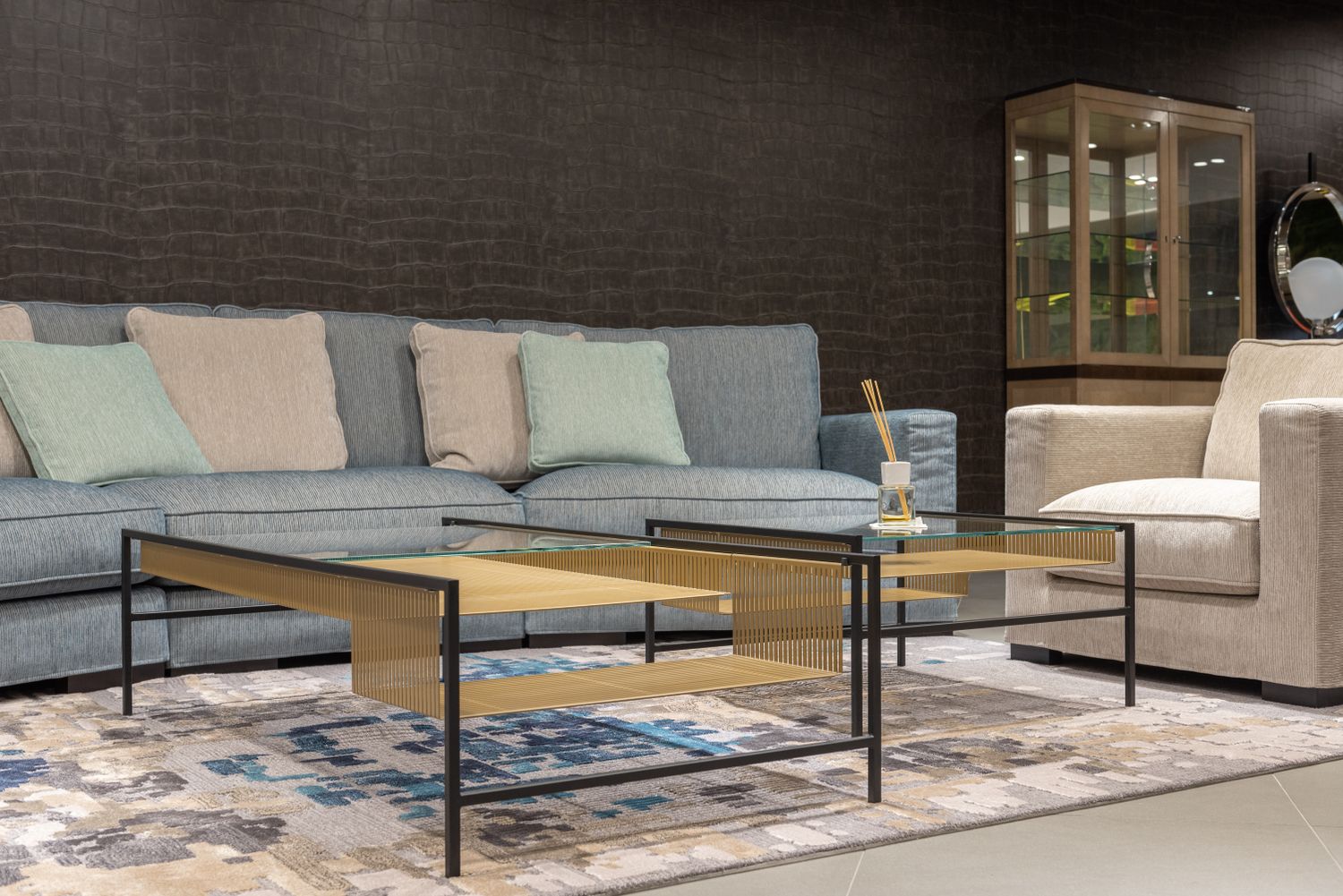 Salon avec un canapé gris, un fauteuil et des tables basses